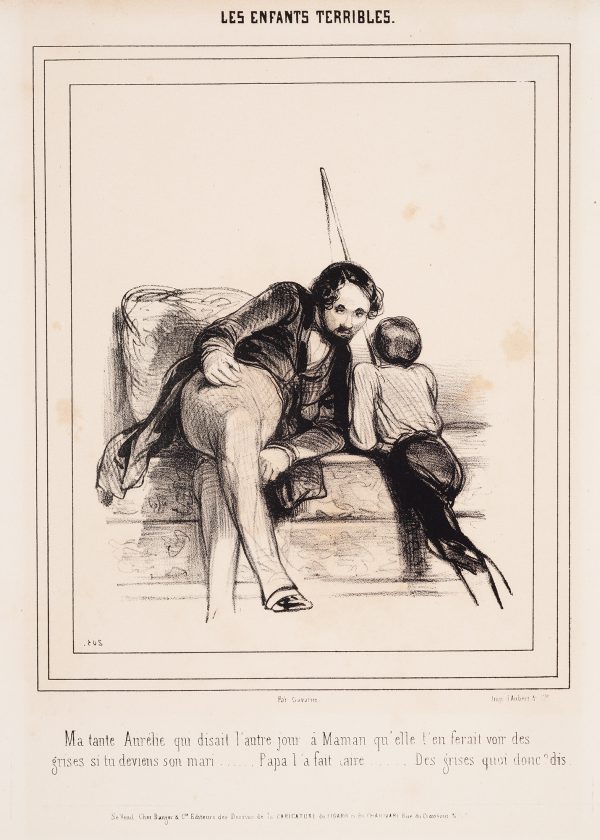 A man sits facing a boy leaning on a couch.