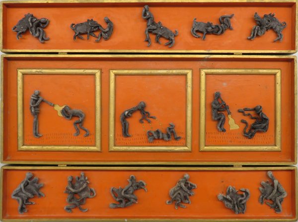17 cast lead figures on an orange and gold background. The figures are grouped with animals and the center three have some additional gold background.