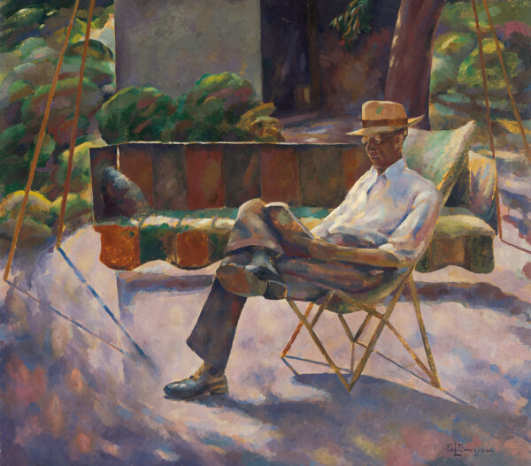 A man wearing a hat sits outside reading.