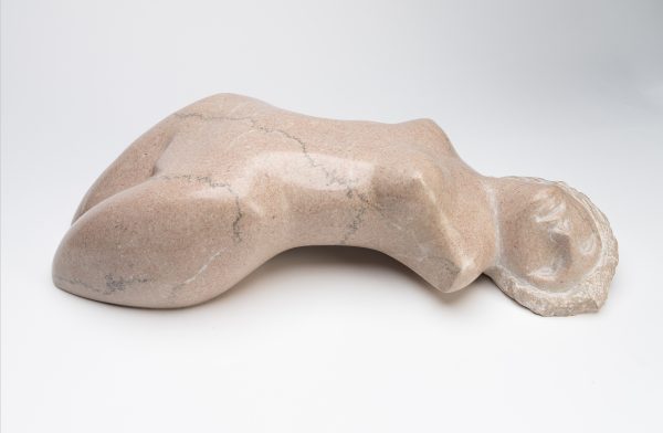 An female nude lies on her back with the sculture ending at her thighs and no arms.