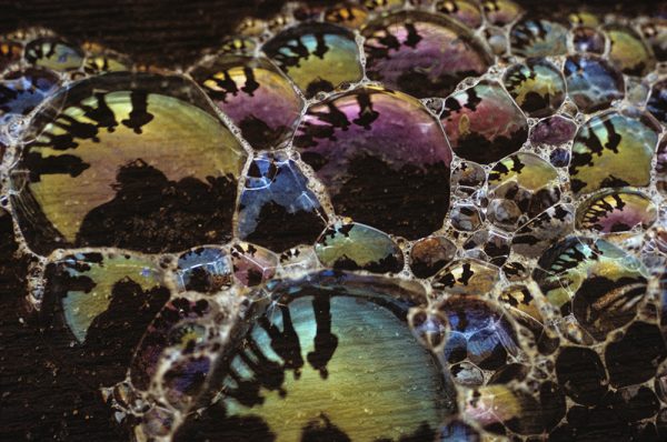 Soap bubbles with multiple people reflected in the bubbles. This photo was among the first prize winners in 1971 Life Magazine photo contest.