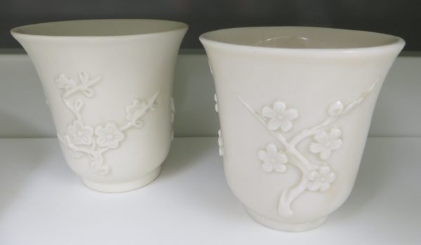 An all white beaker with molded prunus blossoms. Double foor ring.