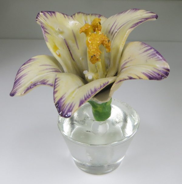 A ceramic lily on a lucite stand.