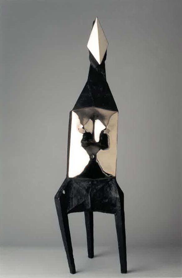 A maquette of an abstracted nude female figure of matte black and polished surfaces.