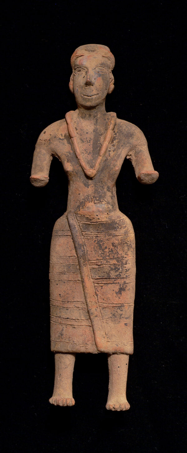 A standing gingerbread female figure with necklace.