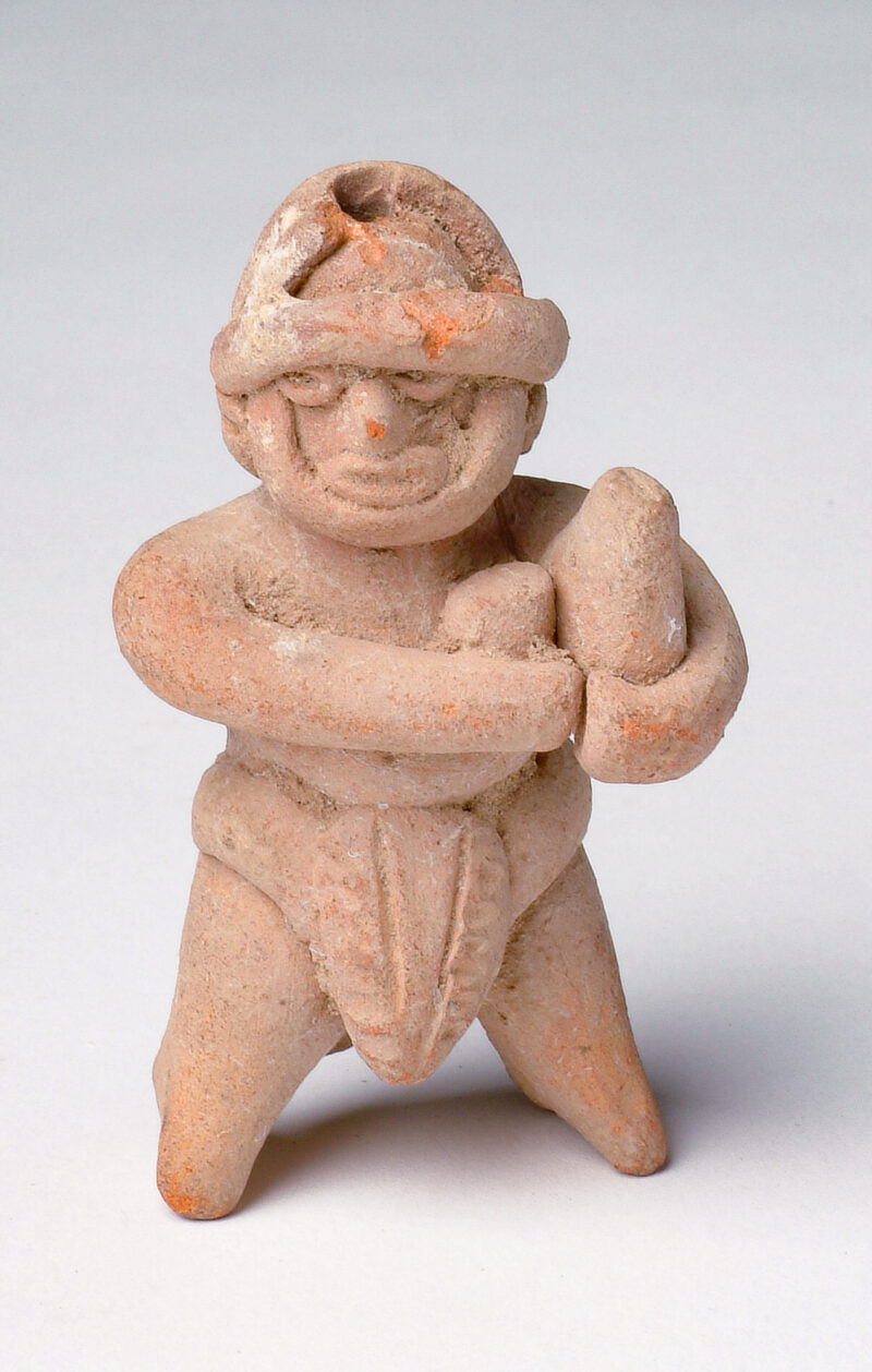 Standing figure holding objects.