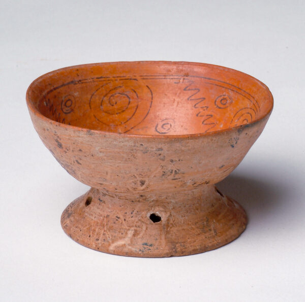 Flared foot under bowl with red slip and dark brown linear decorations inside the bowl.