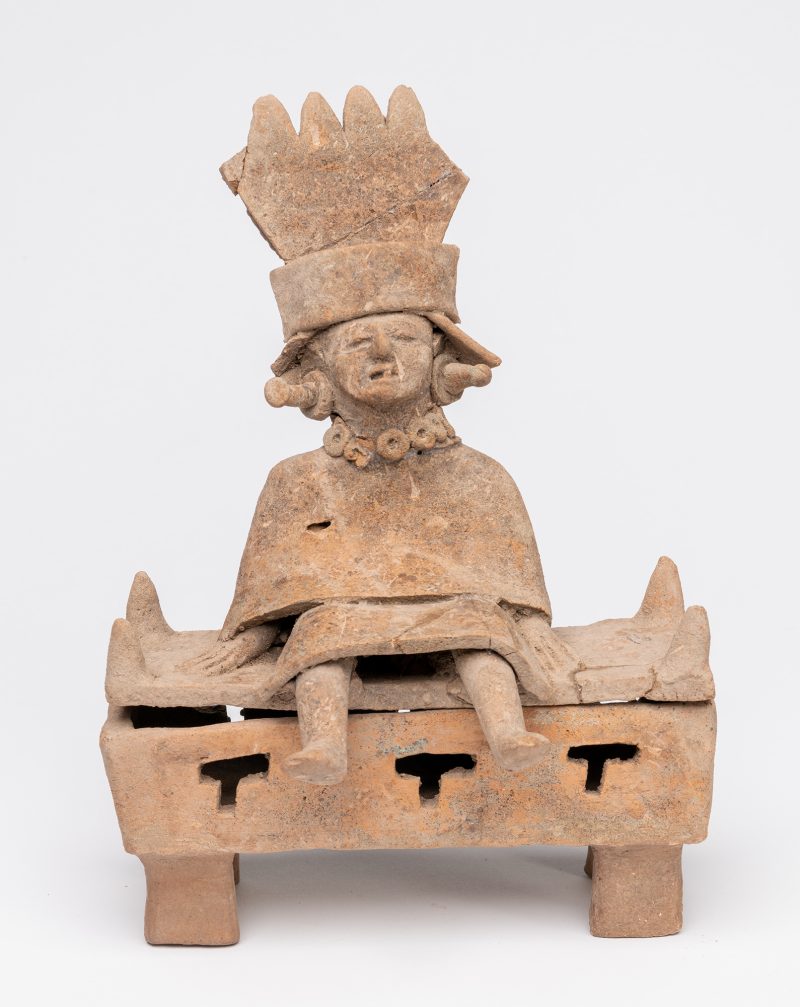 Figure iwth headdress seated on incensor.