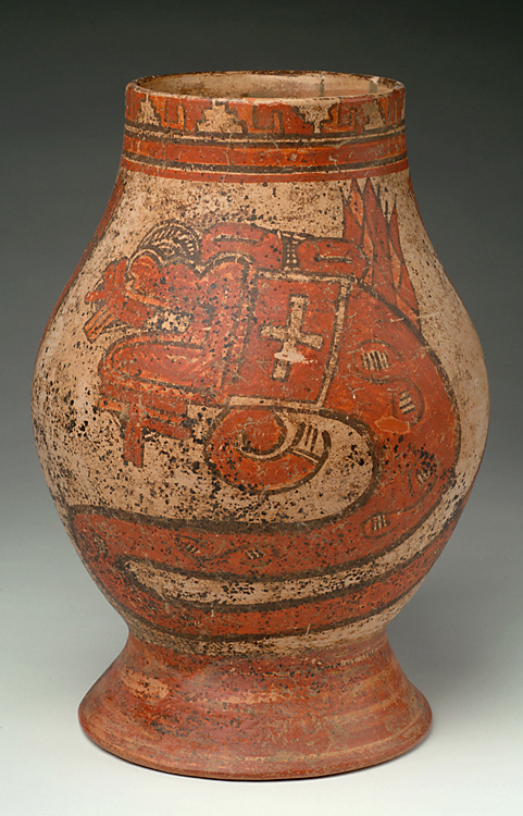 A footed vessel with tan body, red and black slip decoration.