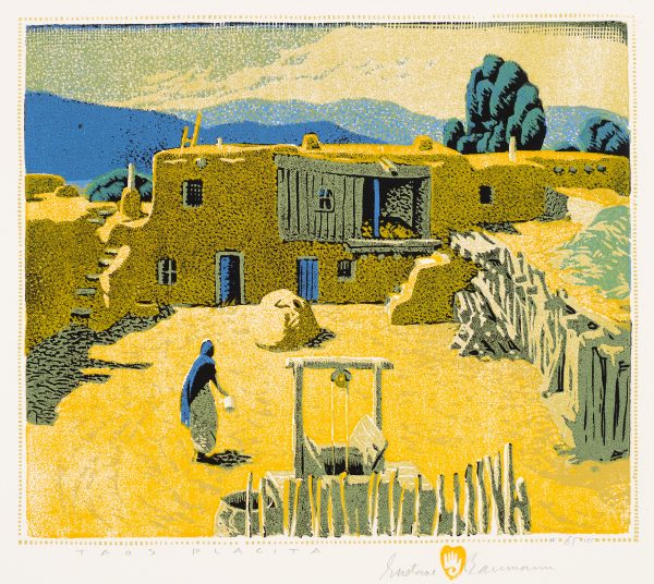 An adobe building with courtyard and mountains in the background.