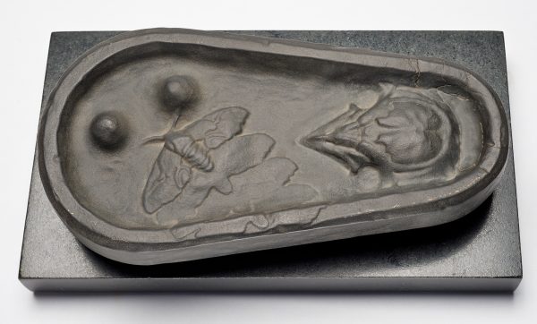 A low relief of a bird and moth