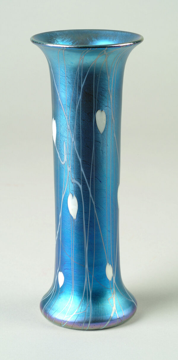 Blown cylindrical vase in blue iridescent glass with applied white glass in a vertical design of heart-shaped leaves and vines.