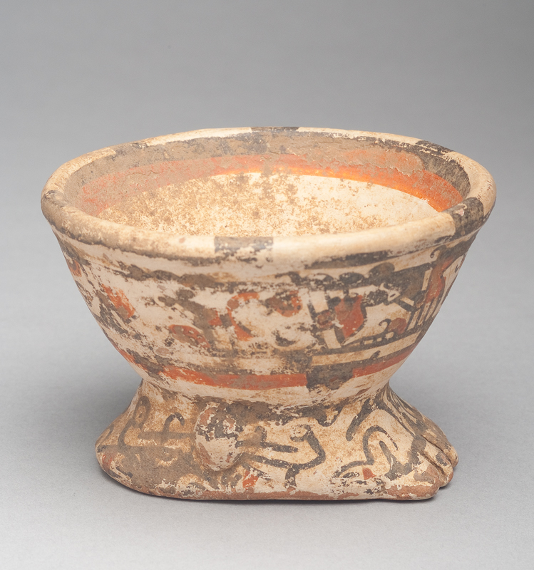 Buff clay body with red ochre and black slip decoration.The bowl is in the shape of a human foot.