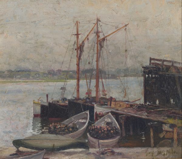 A view of boats at a dock with a shoreline with houses in the background.