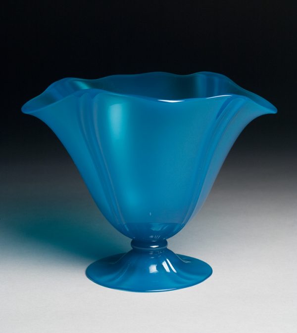 A blue vase with flared foot and four pairs of vertical ribs in a wavy shape.