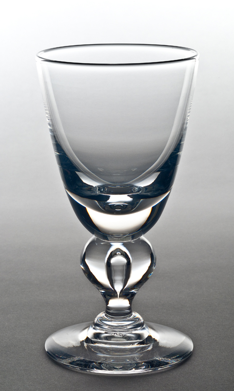 A clear goblet with a inverted tear drop in the round shape above the flared foot.
