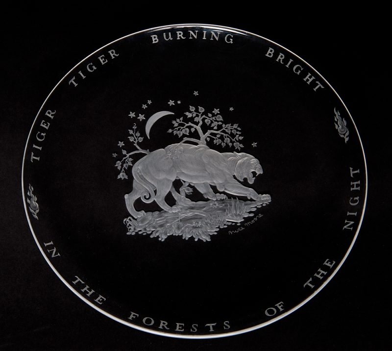 A clear shallow bowl with the image of a tiger at the center and the words of William Blake around the outside.