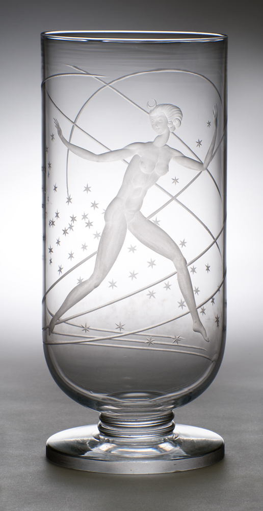 T-34 Shape #7471, A clear column shaped vase engraved with a female nude who is leaping through a design of stars and arcing lines. The figure has a moon above her head.