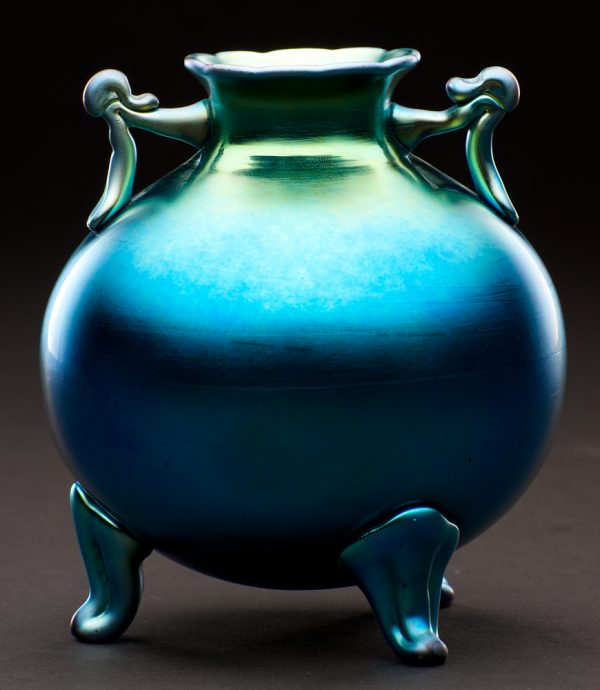 Shape # 6117. A blue round vase with three legs and two handles.