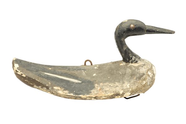 A duck decoy made of carved and painted wood and iron-alloy hardware. The eyes are tacks. The decoy has a black head and tail, gray wings, and light gray color at the breast.