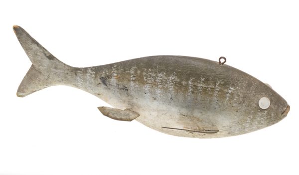A gray fishing lure with white eyes. There are silver strips running vertically across the side of the fish, with a white belly.