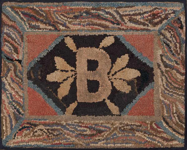A hooked rug of a small rectangle center with the letter B. It has a variegated striped border.