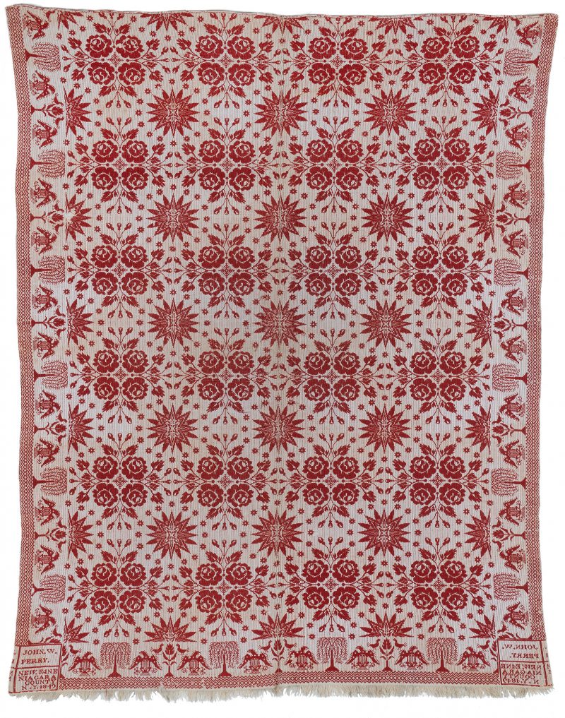 A red and white double weave coverlet with eagles, trees and flower border.