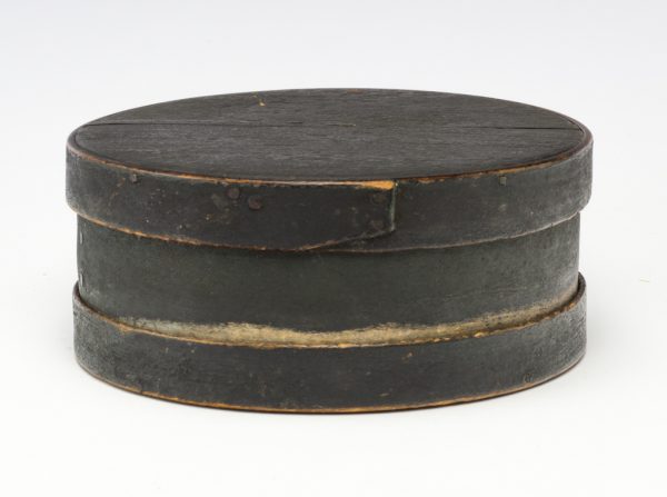 A lidded round box in black and dark green with matching top and bottom.