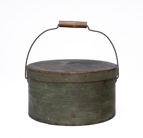 A round lidded box with wire and wood handle in green.
