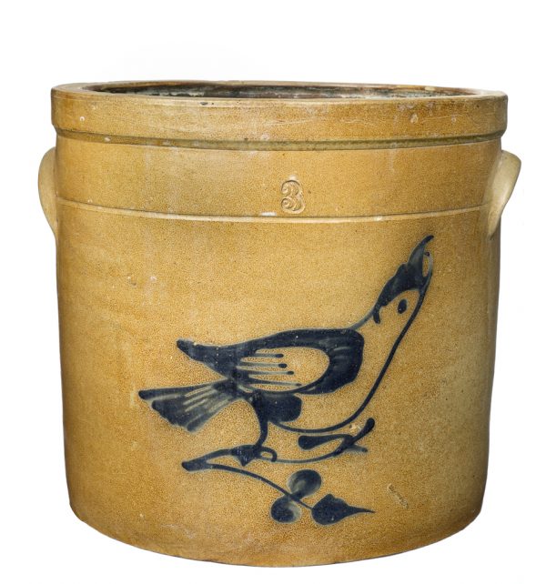 Tan crock with lug handles. Design is of a cobalt bird sitting on a branch.