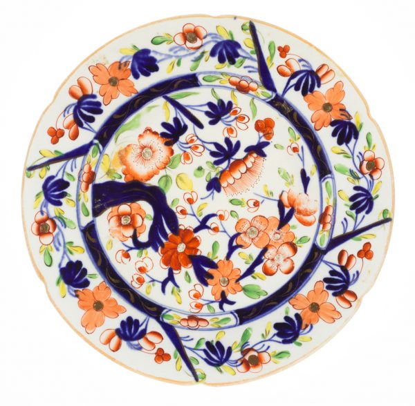 A plate in blue, orange and gold on cream.