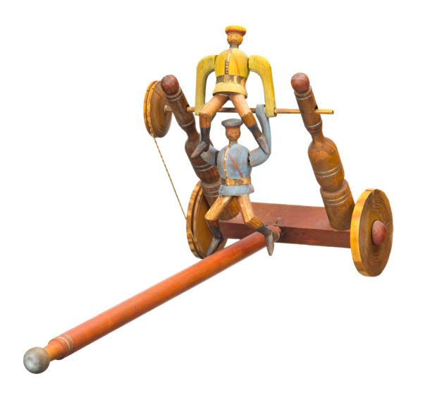 A child's push toy with long handle two acrobats and wheels. A pulley system on one of the wheels controls the movement of two acrobat figures. The toy is made of carved or turned painted (red, yellow and blue) wood pieces, and a piece of string is used to connect the wheels on one side.