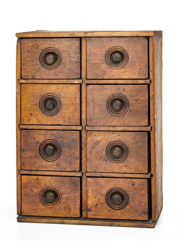 An ochre painted cabinet with evenly spaced eight drawers with round turned knobs.