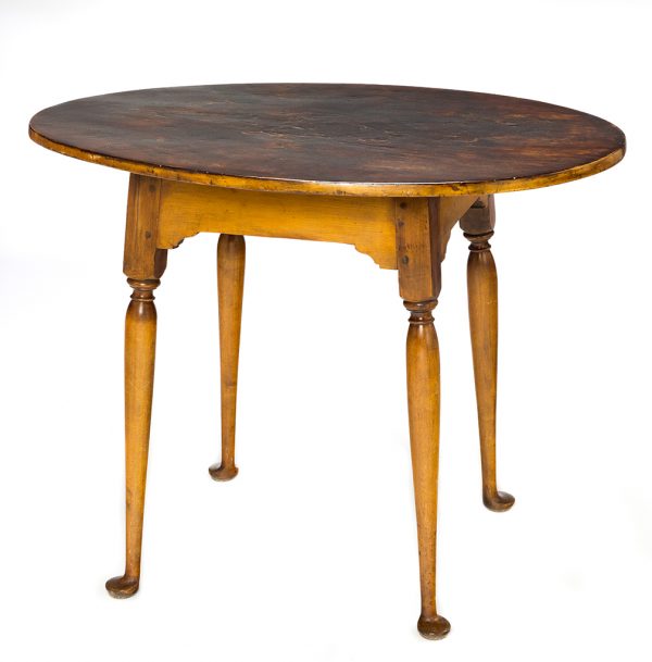 A tea table with round top, turned legs, and pad feet.