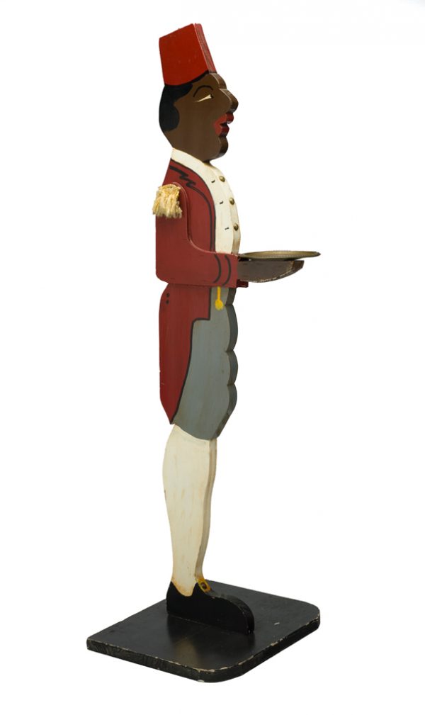 Cardholder. The butler wears a red jacket and fez with gold epaulets on his shoulders. He holds a brass plate