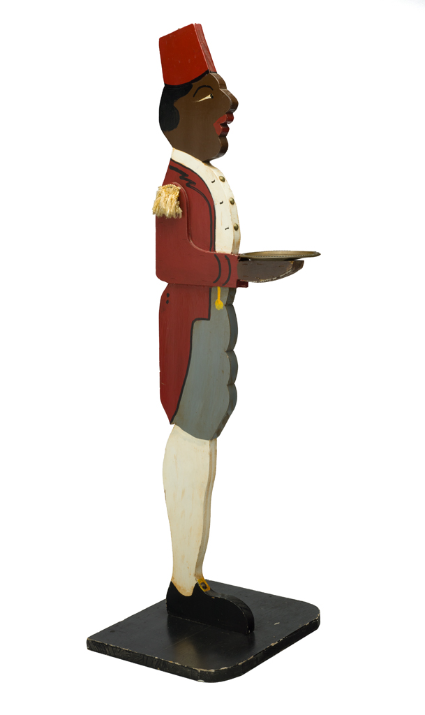 Cardholder. The butler wears a red jacket and fez with gold epaulets on his shoulders. He holds a brass plate
