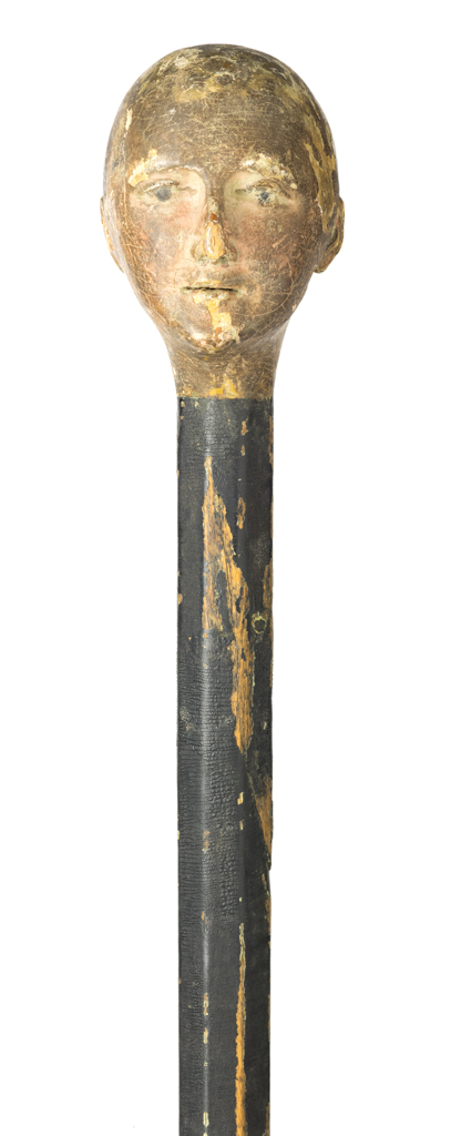 Black cane with carved head at the top.