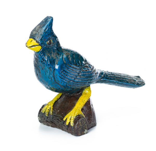 A blue bird with yellow beak and feet, stands on a log.