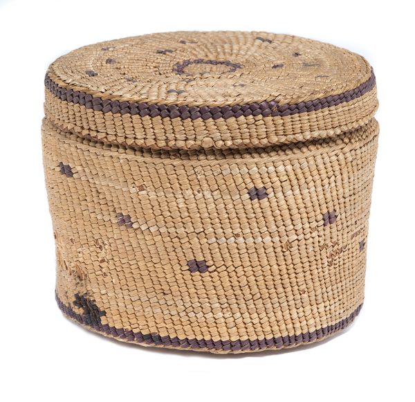 Twinned, undyed plant fiber box with lid. Warp fibers are wider and a darker brown. Wrapped fibers are pale in color with four-stitch design element in purple scattered throughout.