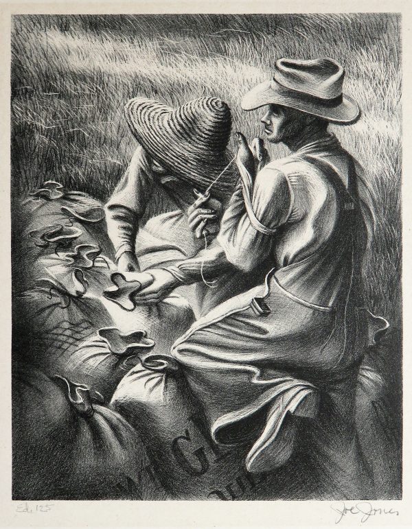 Two workers in hats tie up large bags in a field.