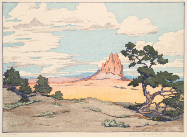 A lone red rocky outcrop in near the center in the background. Clouds are on a blue sky. To the right is a juniper tree and at left are smaller trees.