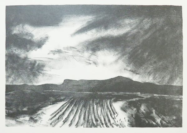 Furrows in a field at center lead to a dark mountain ridge along the horizon line. The sky also has dark threatening clouds.