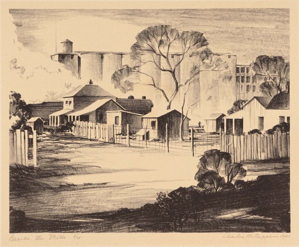 White concrete grain elevators are behind several houses with smaller sheds, trees and fences. A road runs along the foreground.