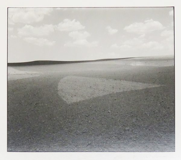 A flat field with a pattern of light that suggests a pointed ice cream cone on its side.