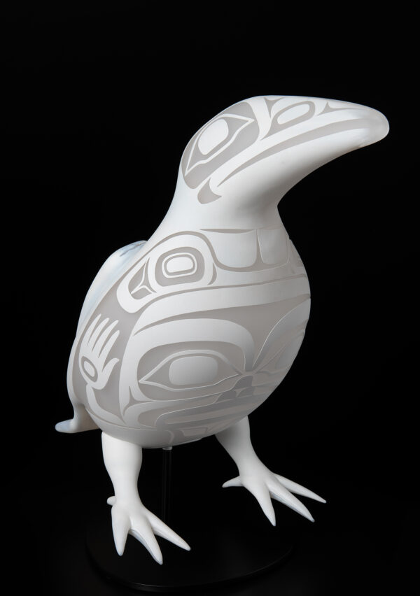 A white raven with traditional designs on the body and head.