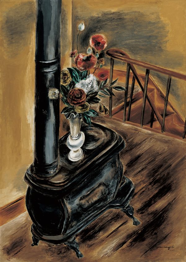 A wood burning stove with a vase of flower on top stands in a room with a stair case in the background.