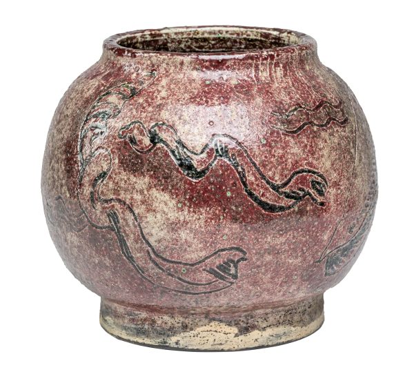 A ceramic bowl with dark glaze, short upper lip and foot.