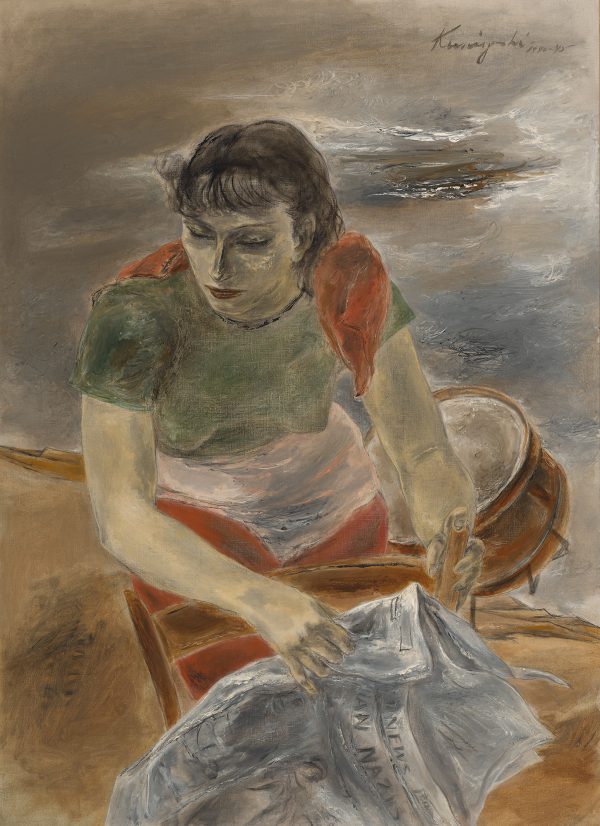 A woman stands in front of a drum holding a newspaper (with the word 