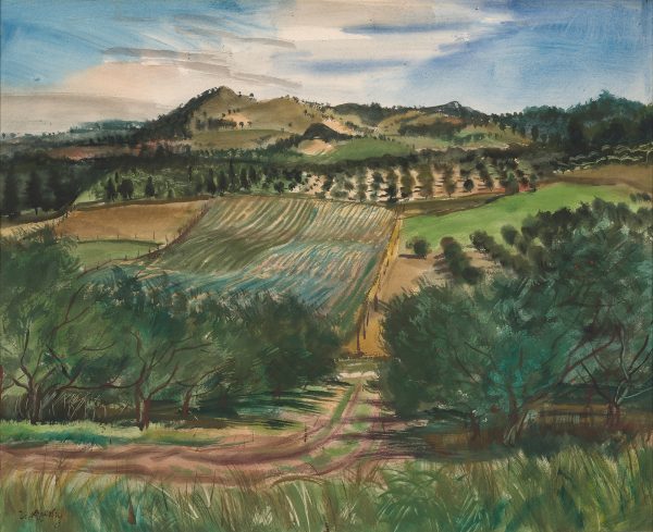 Farmland surrounds a road that disappears into a hillside.