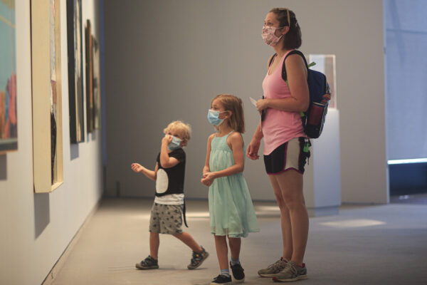 Interior view of the galleries with an adult woman and two children in masks